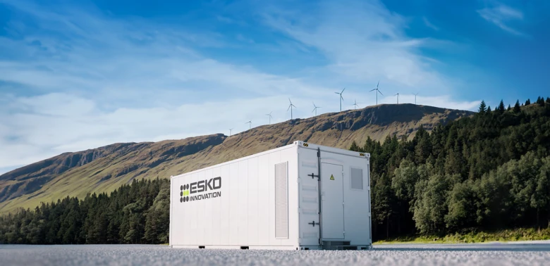 Bateriové úložiště energie před větrnými elektrárnami.