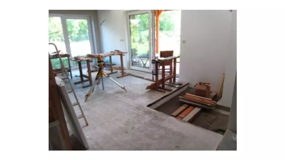 Práce na tepelné izolaci podlahy s polystyrene v bytě.