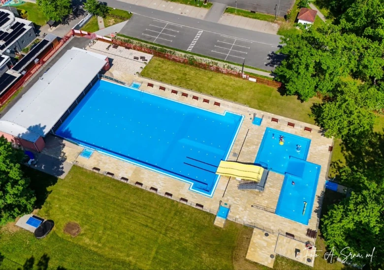 Vzdušný pohled na venkovní bazénové komplex v Ostravici s více plaveckými baseny.
