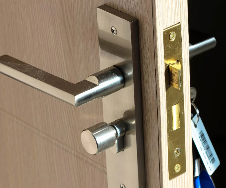Detailní pohled na zámek a kliku dveří s klíči.
