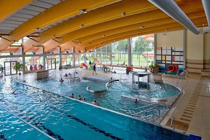 Velké vnitřní plavecké bazénové centrum s dětskou hřištěm.