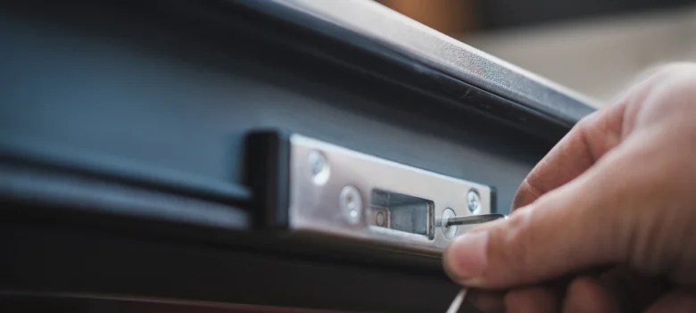 Ruční úprava elektronického zámku vchodových dveří šroubovákem.