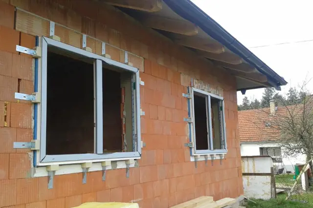 Okno v zdivu s připraveným betonovým překladem pro instalaci.