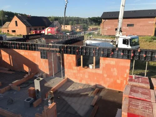 Armování betonového věnce s bedněním na zdivu při stavbě domu.