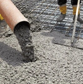 Stírání čerstvého betonu z výlevky na ocelovou mřížku.