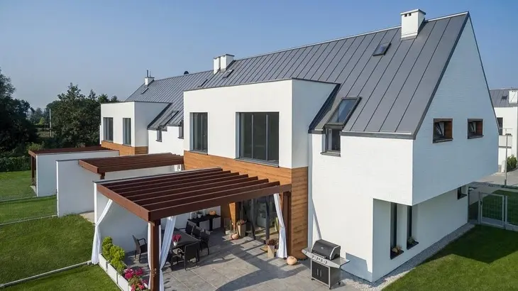 Moderní dům s tmavě šedou falcovanou střešní krytinou.