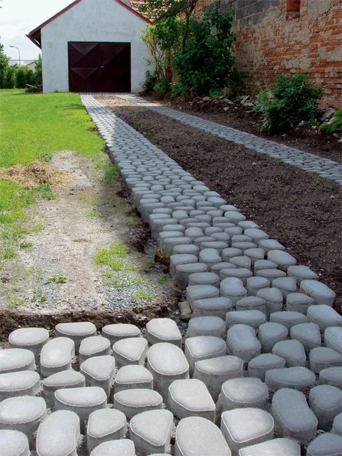 Nová cesta z propustných dlaždic vedoucí k garáži.