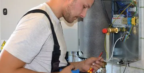 Technik opravuje tepelné čerpadlo v starém domě.