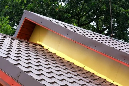 Detail bočního lemování střechy s plechy a izolací.