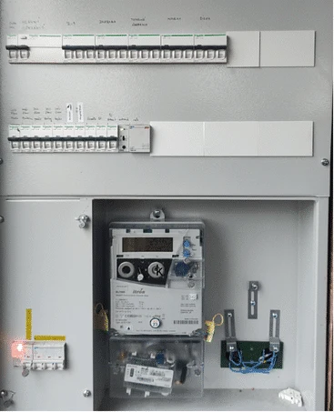 Otevřená elektrická rozvaděč s jističi a měřidlem energie.