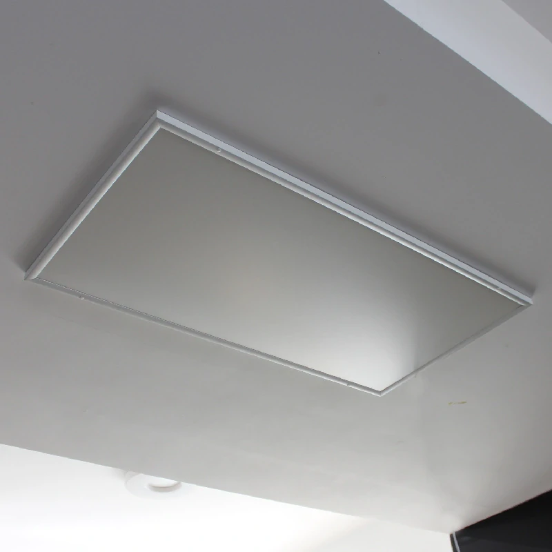 Bílý infračervený topný panel na stropě v interiéru.