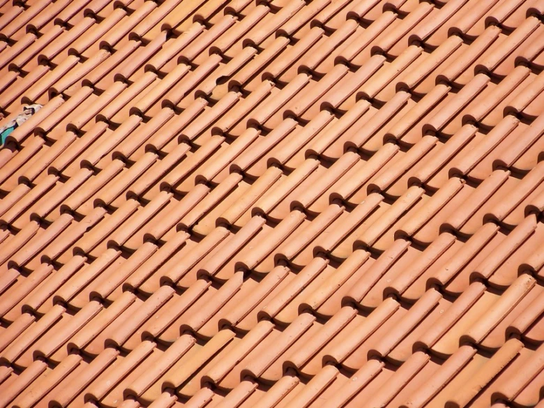 Překrývající se červenohnědé střešní tašky z keramického materiálu.