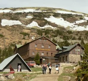 Horská chata Martina bouda s turisty na sněhové hoře.