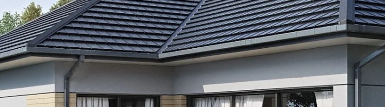 Moderní hranaté okapy s podokapními žlaby na tmavé střechě domu.