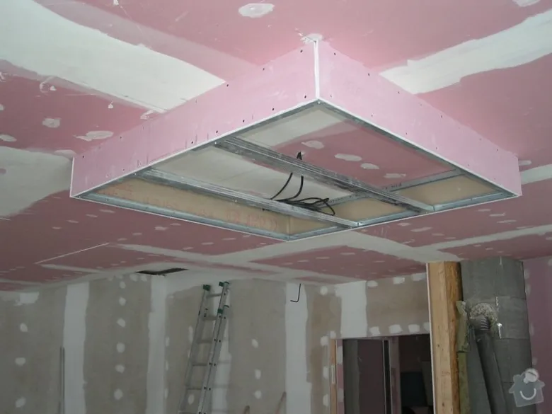Instalace sádrokartonu na strop v budově ve stavbě.