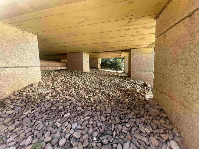 Konkrétní betonové patky pod dřevostavbou na štěrkovém základu.