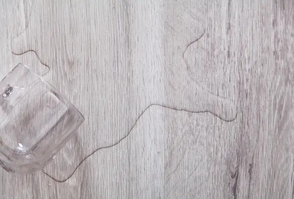 Voda z hrnku na vinylové podlaze v koupelně