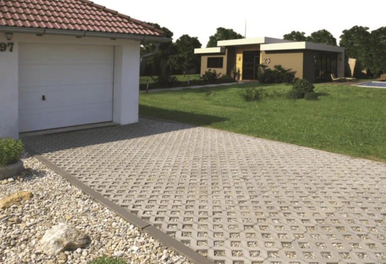 Zatravňovací dlažba s betonovými kostky na dvorek domu.