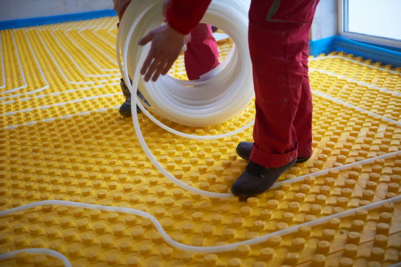 Instalace podlahového topení s rozvinutím potrubí na žlutou vrstvu.