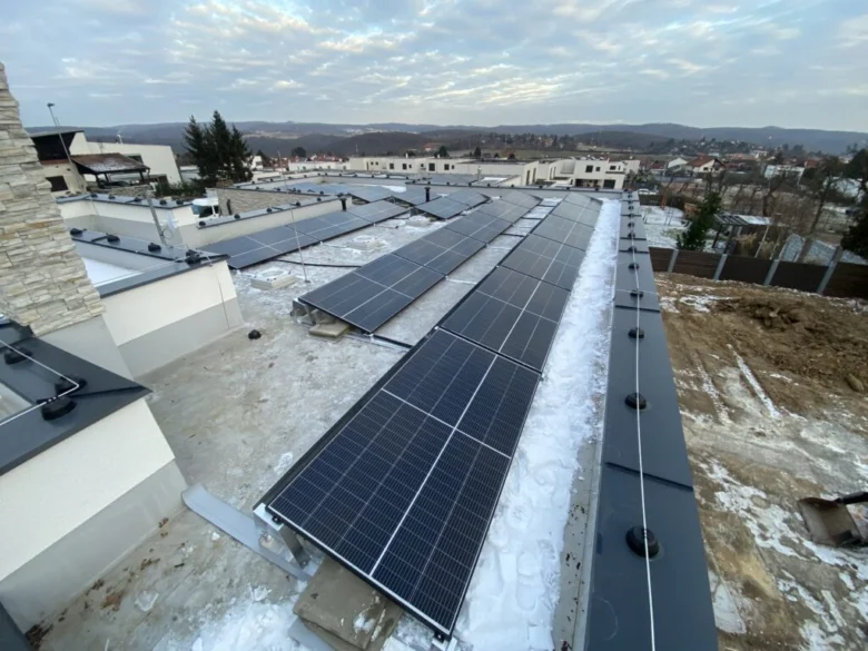 Fotovoltaické panely na střeše budovy v zimě.