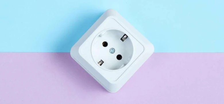 Bílá evropská elektrická zásuvka na modrofialovém pozadí.