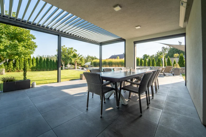 Bioklimatická pergola s jídelním stolem na zahradě.