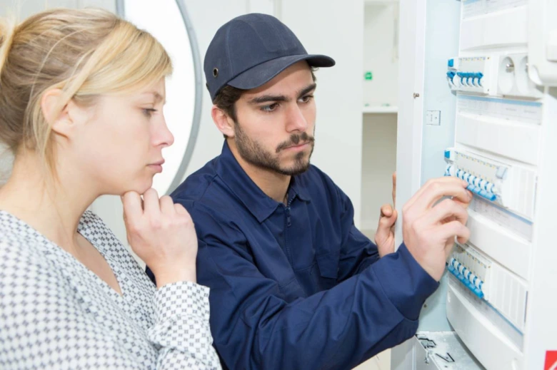 Elektrikář kontroluje jističe v rozvaděči při instalaci.