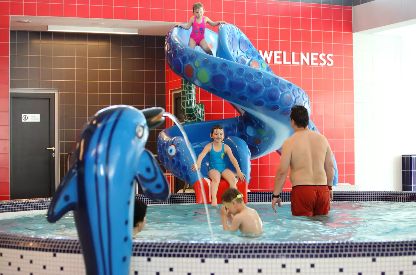 Indoor pool with slide and kids playing