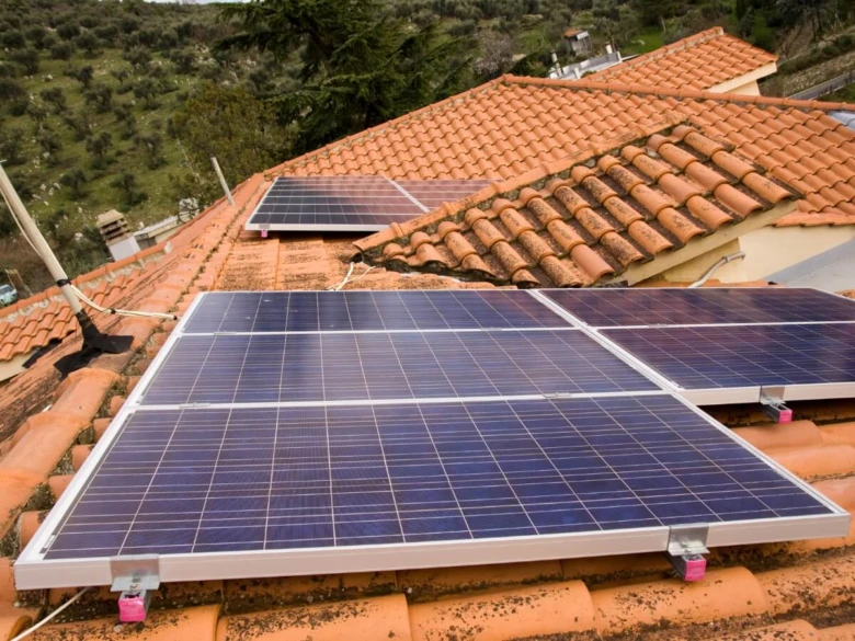 Moduly fotovoltaické na střeše s červenými taškami.