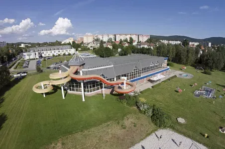 Vzdušný pohled na venkovní bazén v Turnově s vodními skluzavkami.
