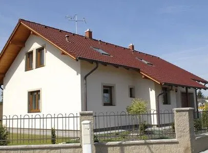 Bílý dům s červenou střechou ukazuje kombinaci barev fasády.