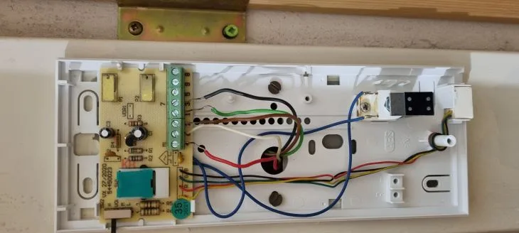 Vnitřní zapojení domovního telefonu s deskou relé a propojenými vodiči.