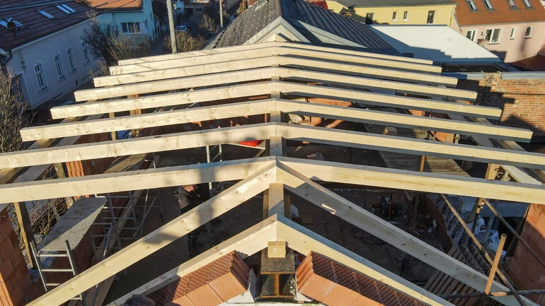 Konstrukce dřevěného krovu pro střechu v procesu stavby.