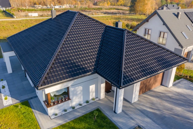 Moderní dům s tmavými střešními taškami na komplexní střechu.