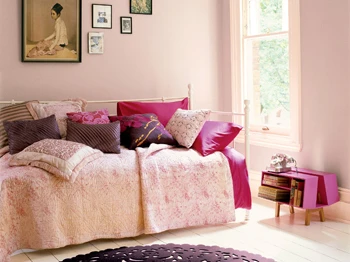 Loft s pastelově růžovými stěnami a kombinací světlejšího tmavšího nábytku.