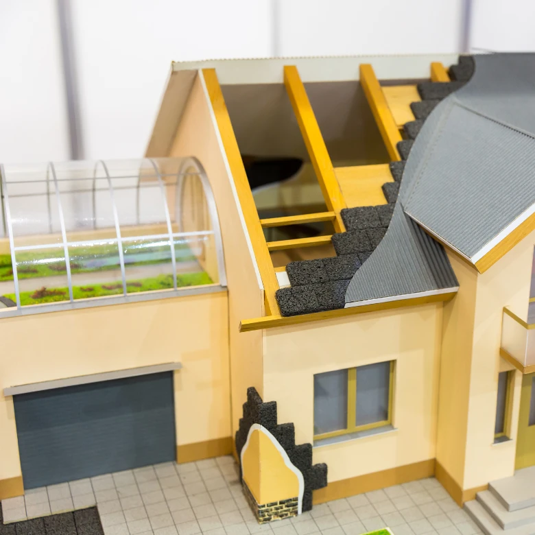 Model domu s průřezem izolací pro vysvětlení tepelného odporu.