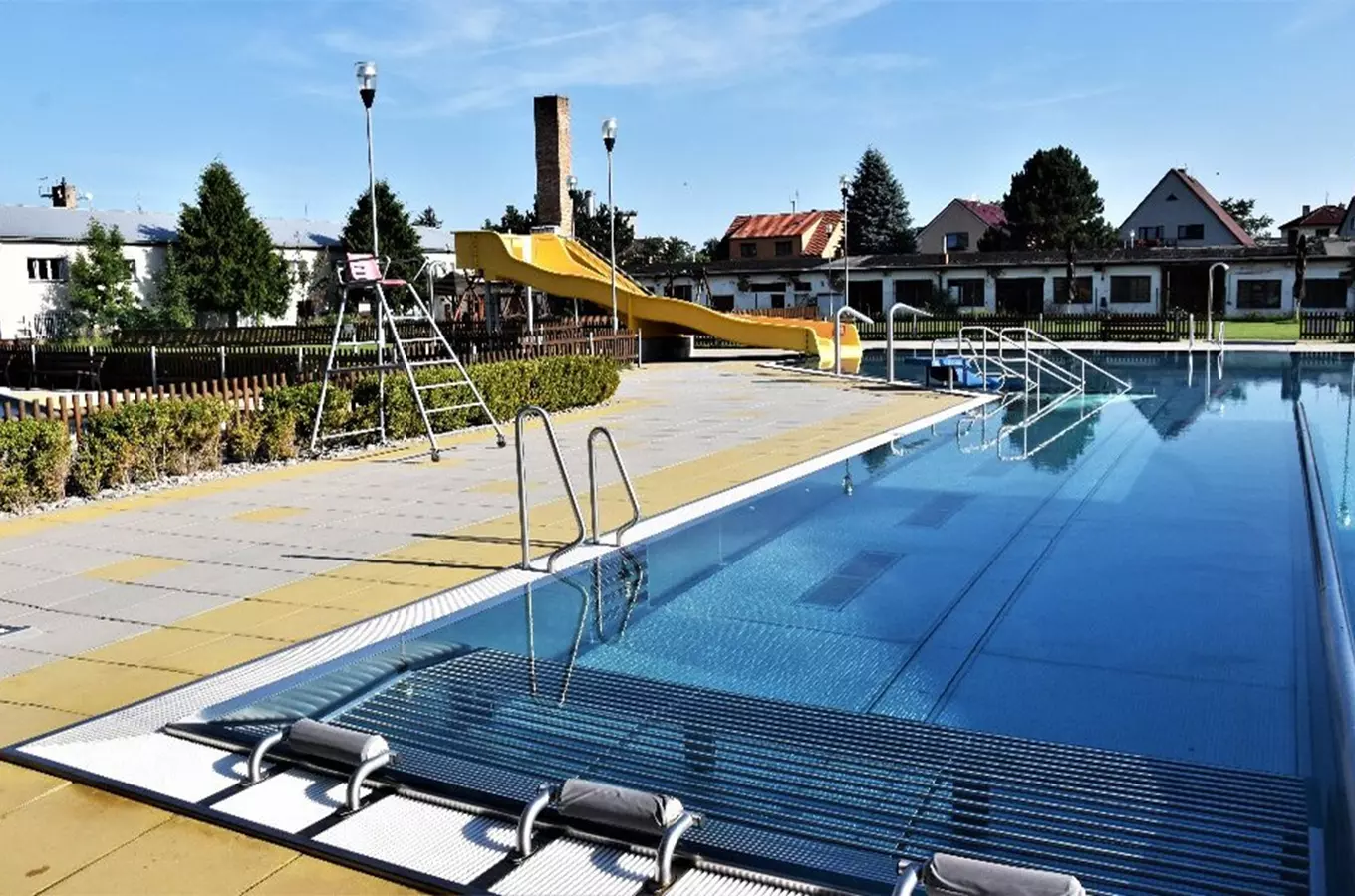 Venkovní bazén s žlutým skluzavkou v obci Blatné.