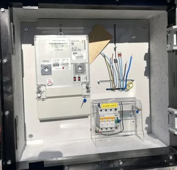 Vnitřek elektrického sloupku s elektroměrem a pojistkami.