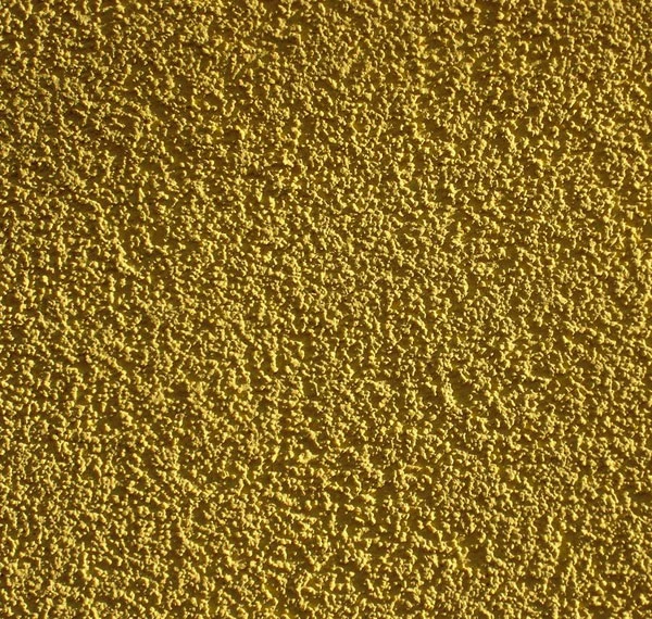 Detail texturované žluté fasádní omítky po dokončení.