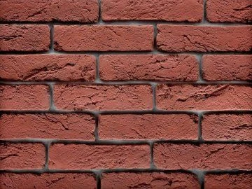 Detail červené cihlové fasády s viditelnými spárkami.