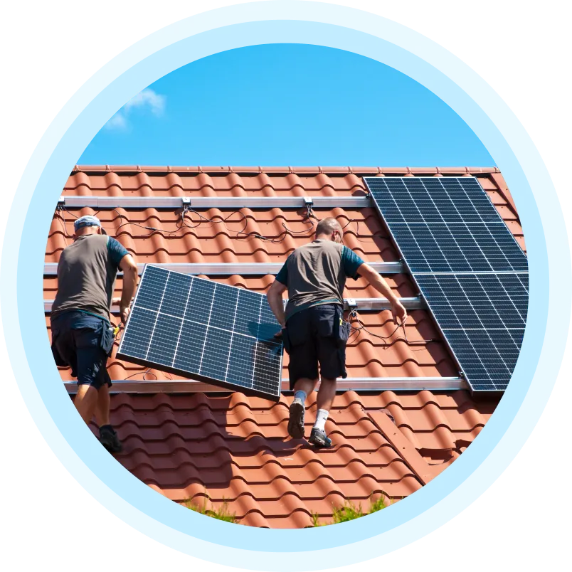 Dva pracovníci montují fotovoltaické panely na střechu v Brně.