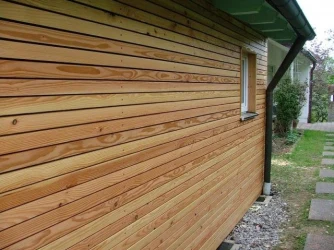 Dřevěná palubková fasáda domu po podbití střechy.