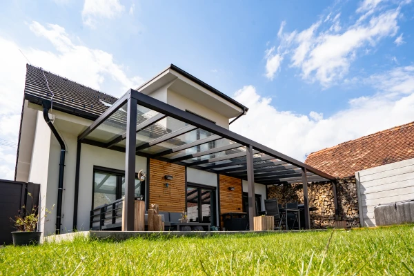 Moderní bioklimatická pergola s průhledným střešním systémem na zahradě.