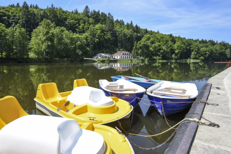 Kolorované pedálové lodě u jezera na přístavišti.