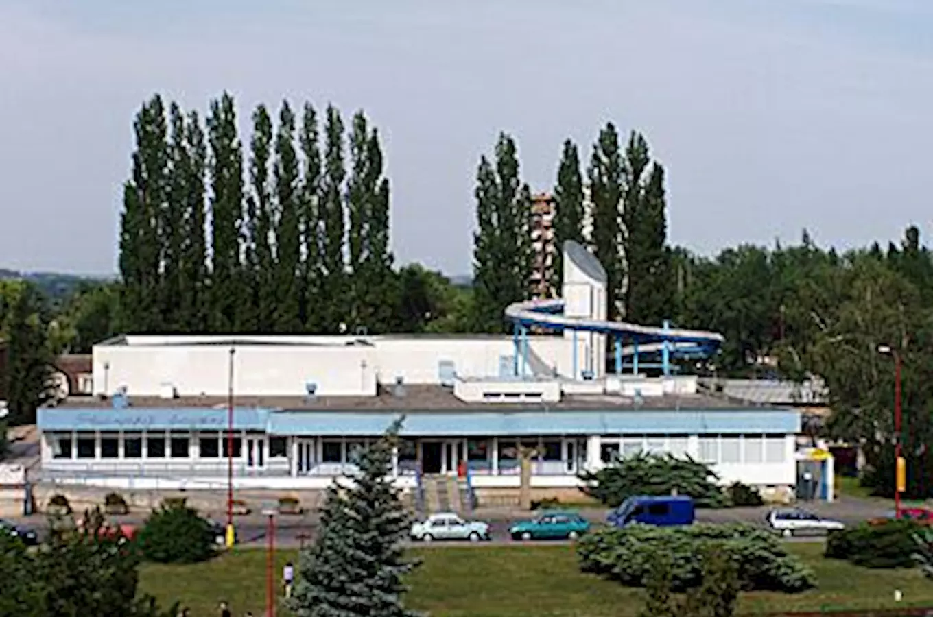 Plavecký bazén v Neratovicích s vodním skluzavkou na střeše.