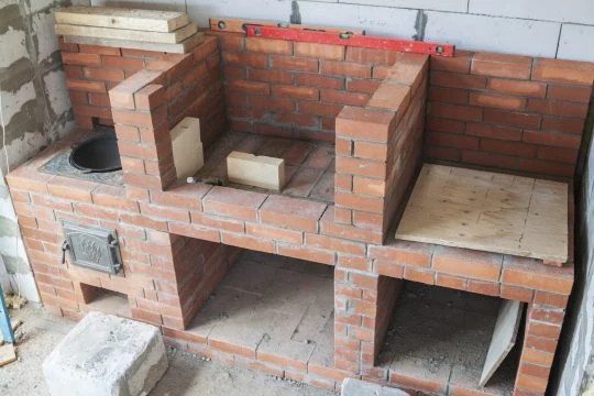 Stavba zahradního grilu z cihel s troubou.
