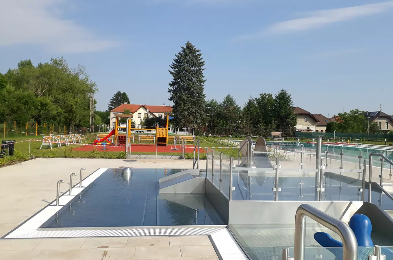 Venkovní bazén ve Vrahovicích s dětským hřištěm a skluzavkami.