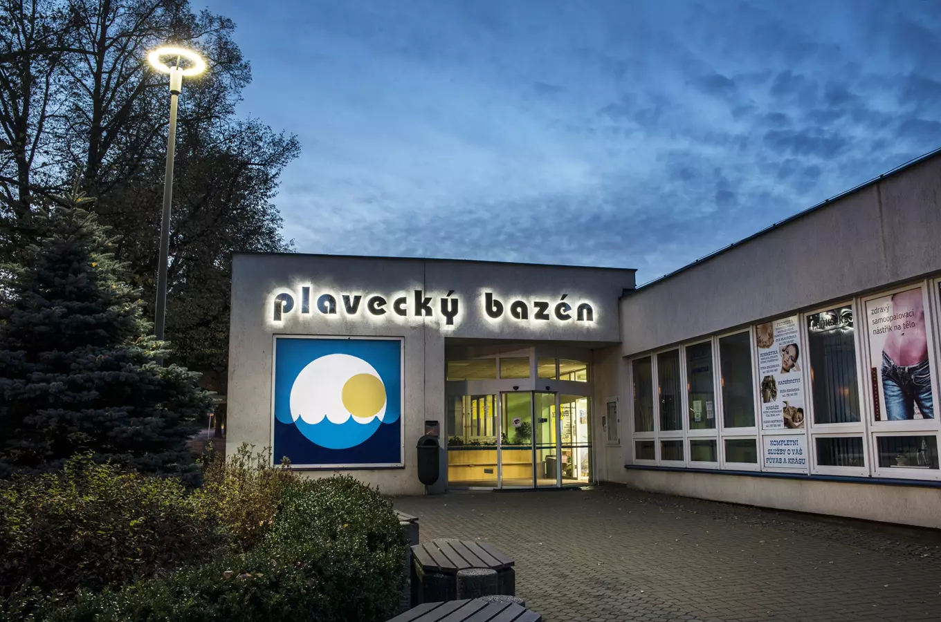 Vstup do plaveckého bazénu s osvětleným nápisem v Pardubicích.