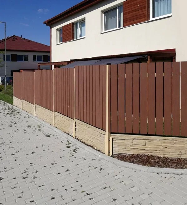 Moderní dřevěný plot s kamenným základem u domu.
