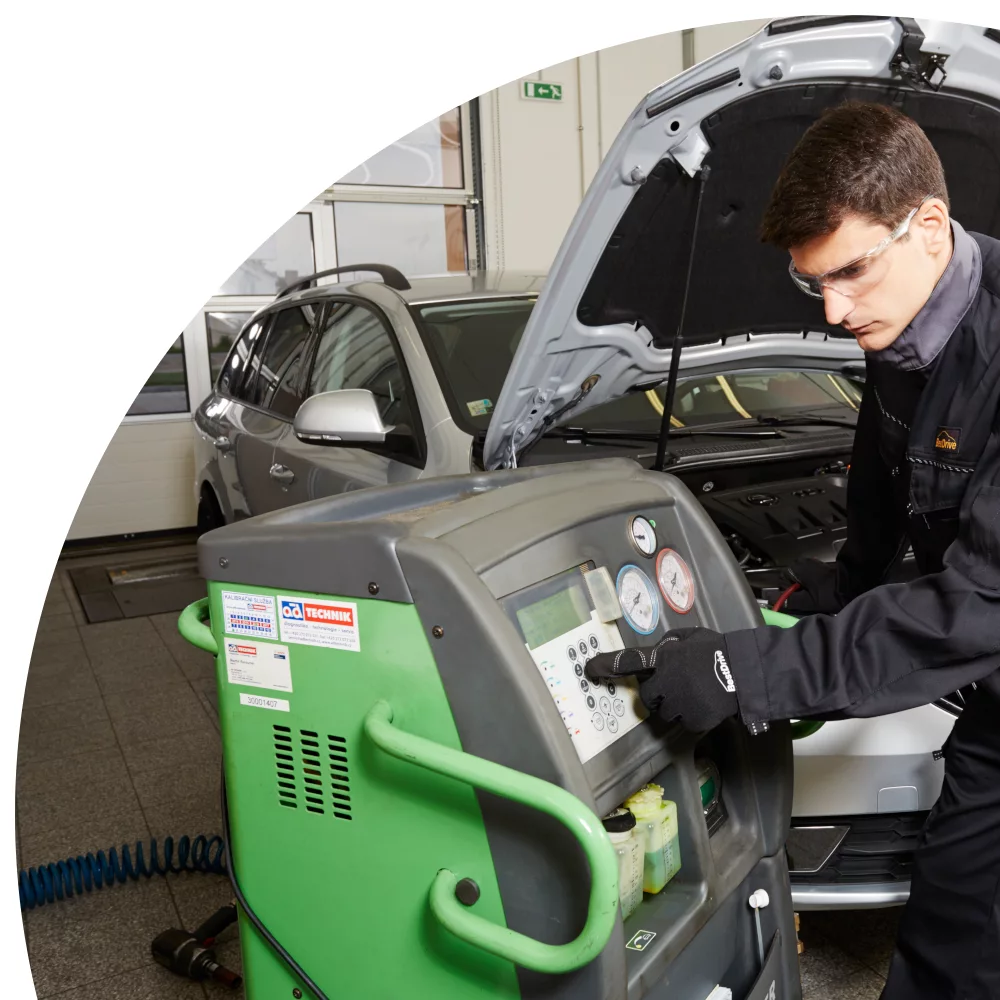 Mechanic using ac machine on car